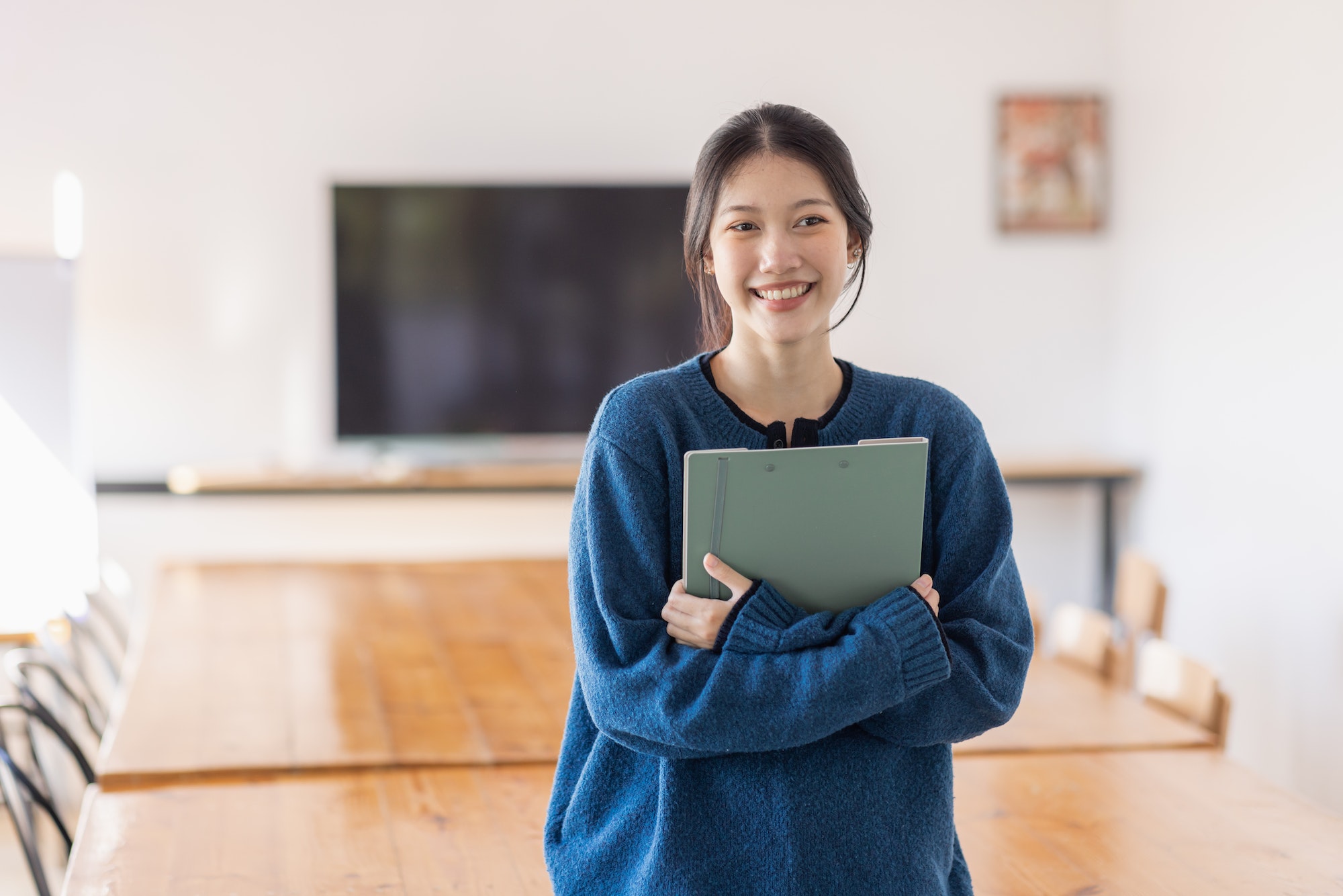 Smiling Asian female student enhancing her future by attending regular lectures